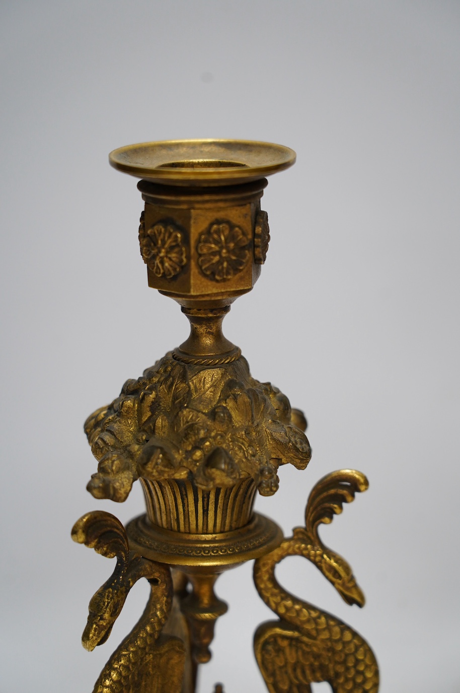 A pair of Empire style ormolu candlesticks, 20cm. Condition - fair to good